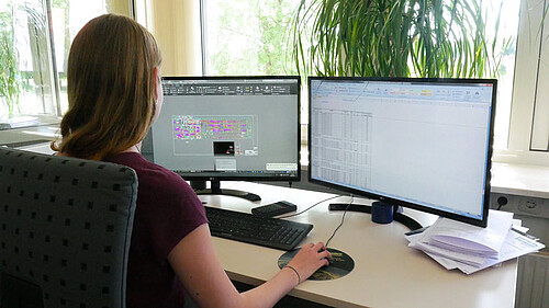 Mitarbeitende sitzt vor zwei Monitoren und konstruiert technische CAD Zeichnung